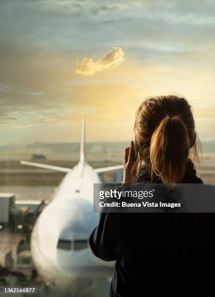 woman watching airplane and talking on the phone. - woman blond looking left window photos et images de collection