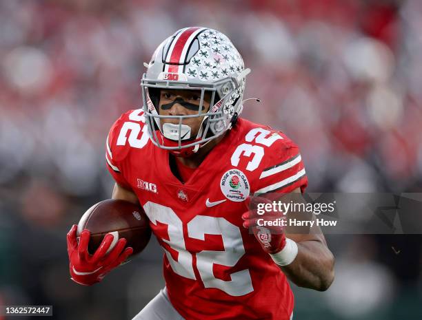 TreVeyon Henderson of the Ohio State Buckeyes carries the ball during a 48-45 Ohio State Buckeyes win at Rose Bowl on January 01, 2022 in Pasadena,...