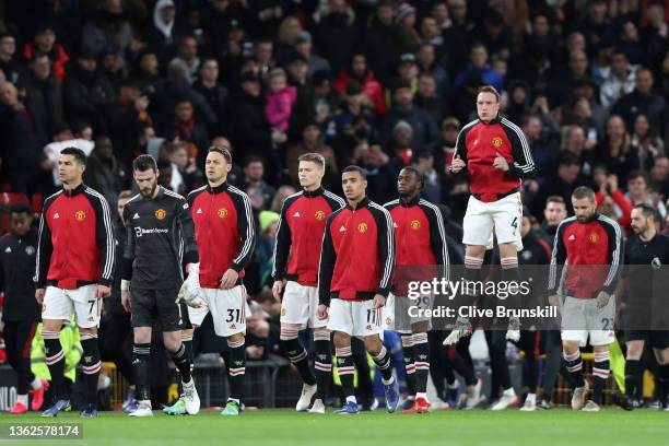 Cristiano Ronaldo of Manchester United leads their side out onto the pitch as Phil Jones jumps up prior to the Premier League match between...