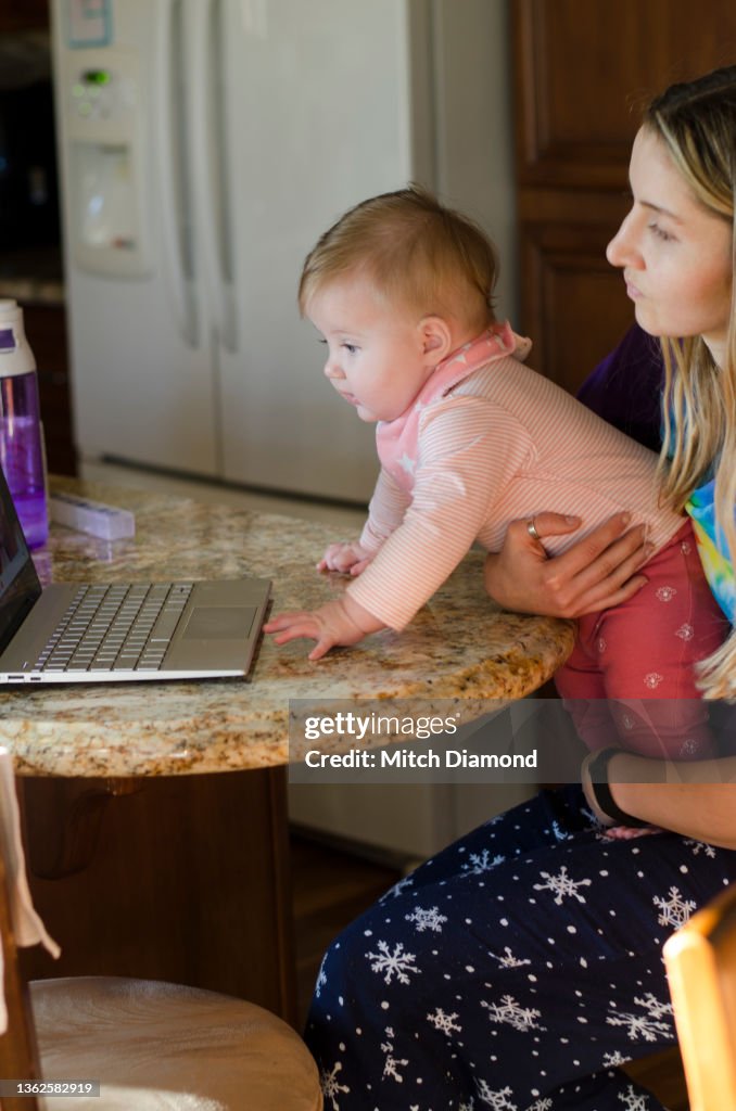 Young Mother With Daughter Using Computer Photo - Getty Images