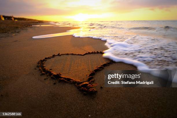 heart drawn on the sand at dawn - footprint heart shape stock pictures, royalty-free photos & images