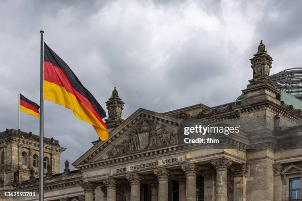 reichstag building in berlin with german flags - central council stock pictures, royalty-free photos & images