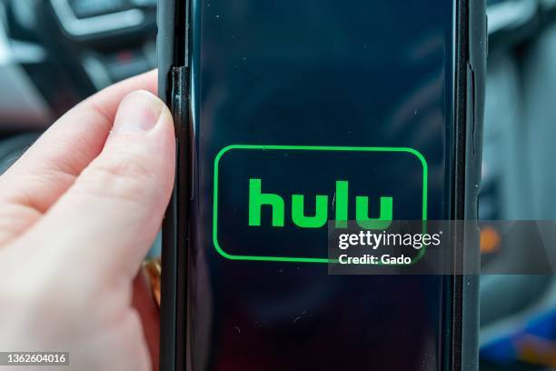 Person's hand holding a smartphone displaying the logo for streaming service Hulu, Lafayette, California, December 5, 2021. Photo courtesy Tech...
