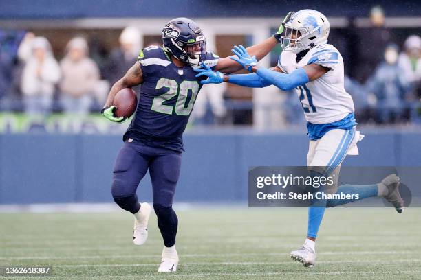 Rashaad Penny of the Seattle Seahawks stiff arms Tracy Walker III of the Detroit Lions during the first half at Lumen Field on January 02, 2022 in...