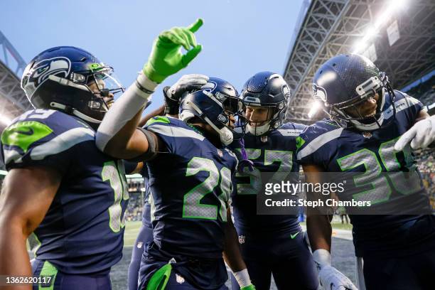 Ugo Amadi of the Seattle Seahawks celebrates his interception with teammates during the fourth quarter against the Detroit Lions at Lumen Field on...
