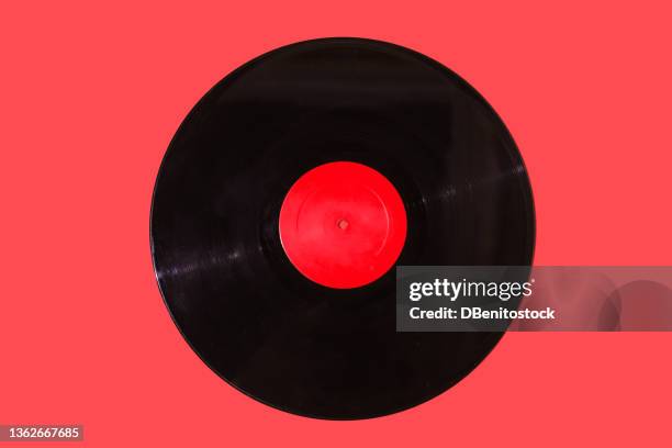 music vinyl record with red label on red background. music, disco, sound, retro, vintage, analog and analog record concept. - lp fotografías e imágenes de stock