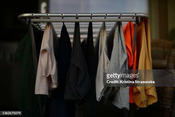 clothes in different colors hanging on a dry rail - shirt no people stock-fotos und bilder