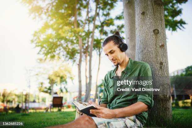 young man learning in the park - travel writer stock pictures, royalty-free photos & images