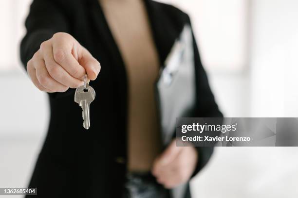 close up view of a real estate agent giving the house key to the new owner. - agent and handing keys stockfoto's en -beelden