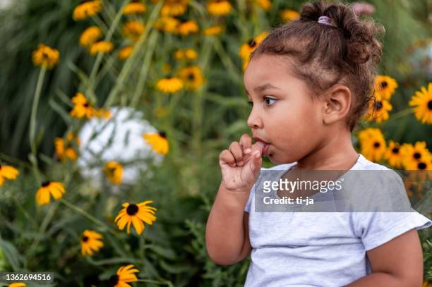 niña con un dedo en la boca al aire libre - finger in mouth fotografías e imágenes de stock