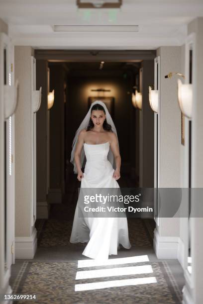 young confident bride walks down the corridor - bride walking stock pictures, royalty-free photos & images