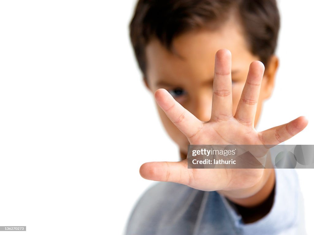 Young boy with hand outstretched makes a stop gesture