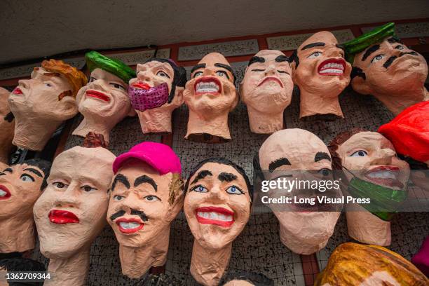 Artisans display for sale several burning dolls that show popular television, movie and politicians related topics and characters in Pasto, Narino -...