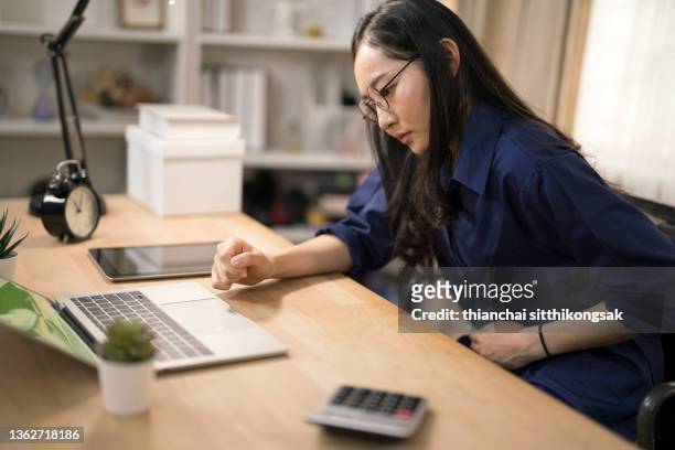 shot of young woman suffering from stomach cramps in office. - regla fotografías e imágenes de stock