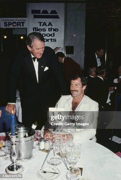 Australia fast bowler Dennis Lillee pictured at a Confederation of Australian Sport dinner talking with Australian Prime Minister Malcolm Fraser...