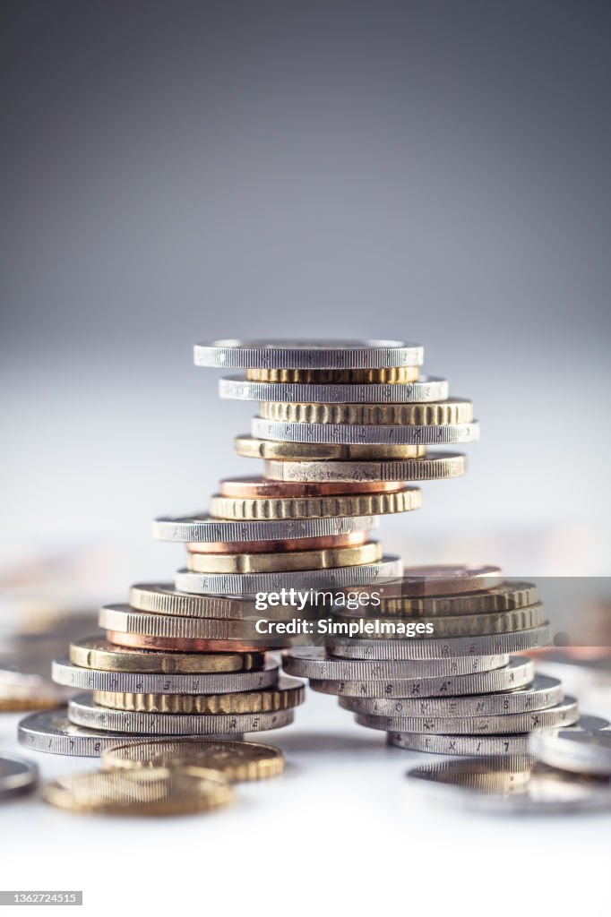 A tower with euro coins balances on the white table.