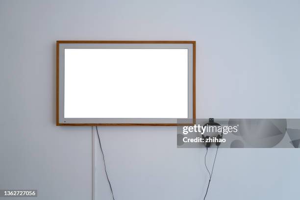 a device screen and earphones on a white wall - monitor wall stock-fotos und bilder