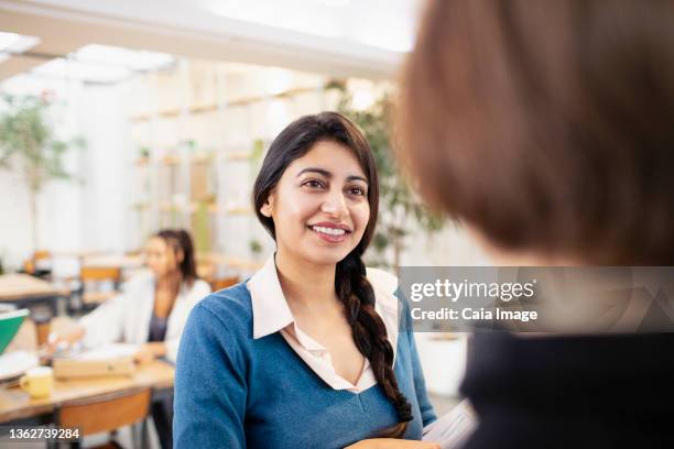 smiling businesswomen talking in office - caiaimage stock-fotos und bilder