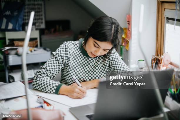 hispanic college student doing some home works from home with laptop - cute college girl stockfoto's en -beelden