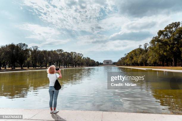 tourist takes photos in washington, d.c - reflecting pool stock pictures, royalty-free photos & images