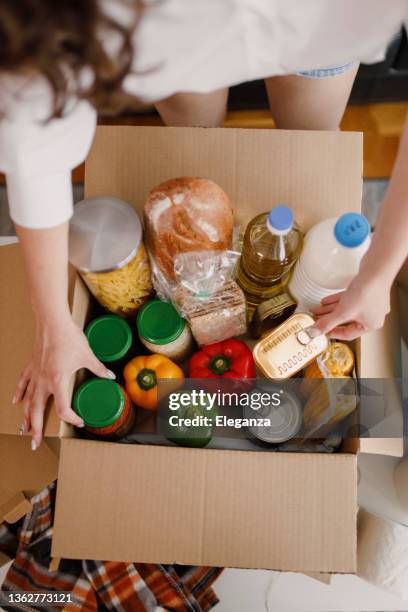 details of volunteer with box of food for poor - não perecíveis imagens e fotografias de stock
