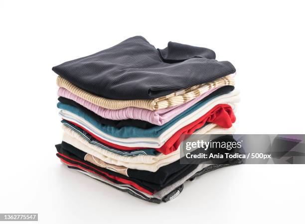 stacks of clothing on white,close-up of stacked books against white background - roupa imagens e fotografias de stock