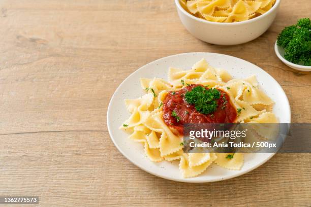 farfalle pasta in tomato sauce with parsley - farfalle stock-fotos und bilder