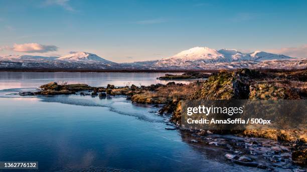 scenic view of lake by snowcapped mountains against sky - landslag stock pictures, royalty-free photos & images