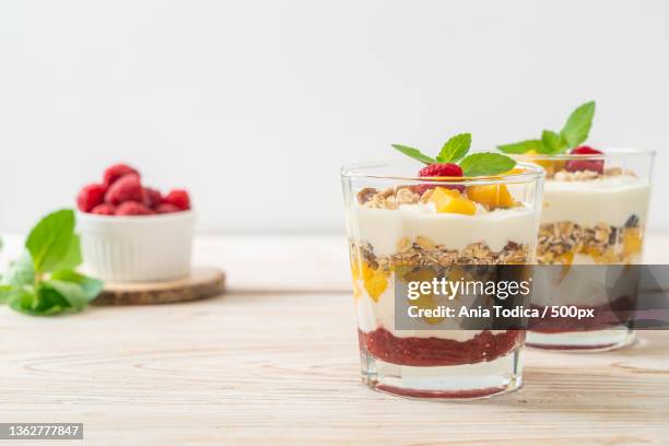 homemade mango and raspberry with yogurt and granola - mango smoothie stock pictures, royalty-free photos & images