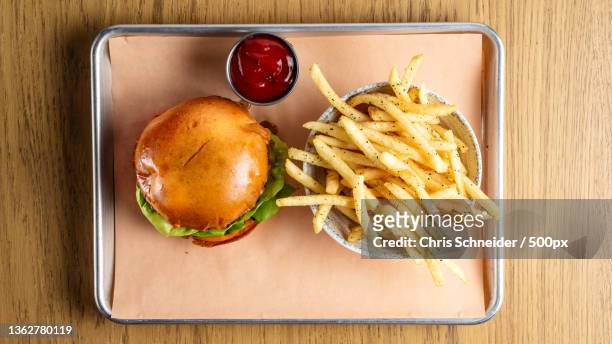 american food,directly above shot of burger and french fries in plate on table,massachusetts,united states,usa - cheeseburger and fries stock-fotos und bilder