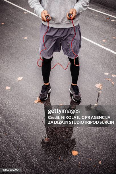 young man with jumping rope on an autumn day training - horizontal bar stock pictures, royalty-free photos & images