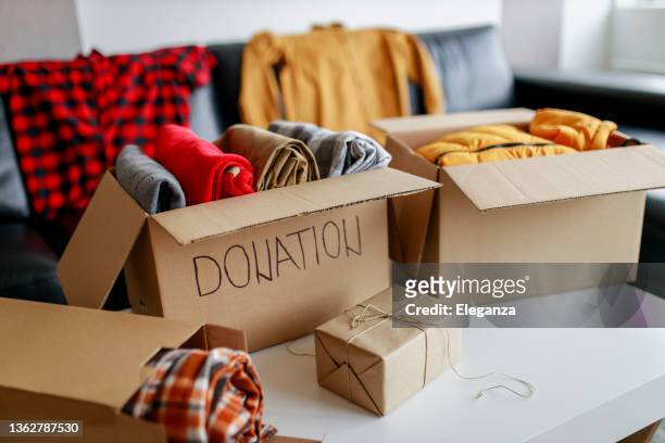 donation box with stuff (blankets and clothes) - winter coats stockfoto's en -beelden