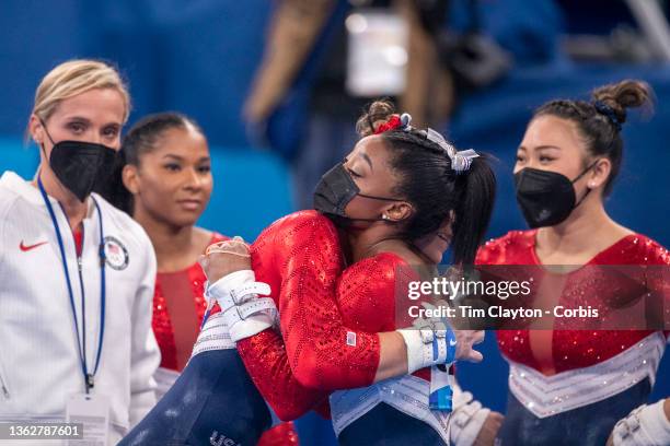 Simone Biles of the United States is embraced by Grace McCallum as she tells team mates Sunisa Lee, Jordan Chiles and Grace McCallum she is pulling...