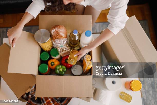 details of volunteer with box of food for poor - food bank box stock pictures, royalty-free photos & images