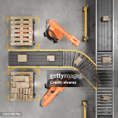 Industrial robots working on a conveyor belt in a smart warehouse Industrial robots working on a conveyor belt in a smart warehouse