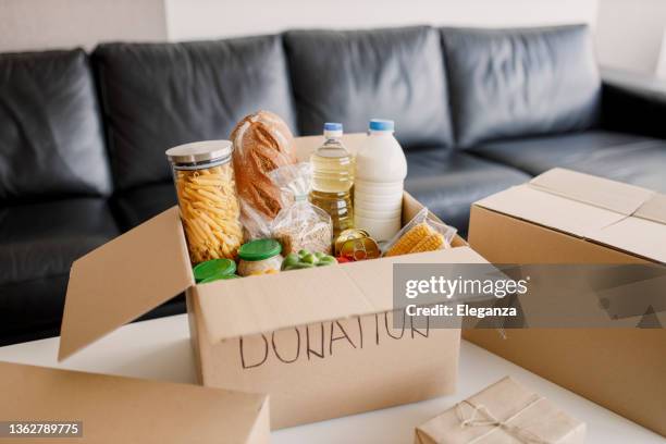high angle view of a cardboard box filled with multicolored non-perishable canned goods, conserves, sauces and oils - não perecíveis imagens e fotografias de stock