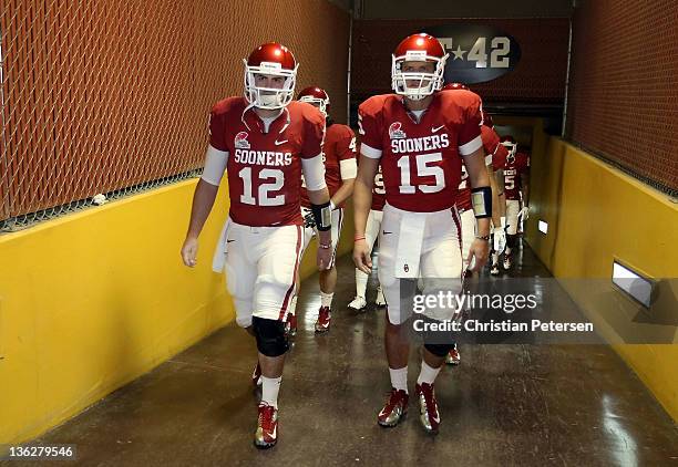 Quarterbacks Landry Jones and Drew Allen of the Oklahoma Sooners walk out onto the field before the Insight Bowl against the Iowa Hawkeyes at Sun...