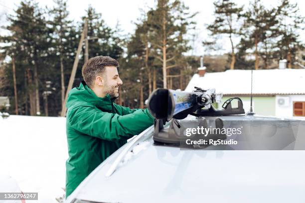 happy man preparing to go on a ski vacation - car roof stock pictures, royalty-free photos & images