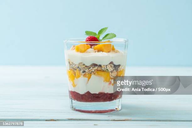 homemade mango and raspberry with yogurt and granola - mango smoothie stock pictures, royalty-free photos & images