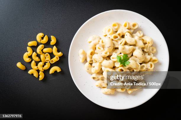 macaroni and cheese with herbs,directly above shot of pasta in plate on black background - mac and cheese stock pictures, royalty-free photos & images