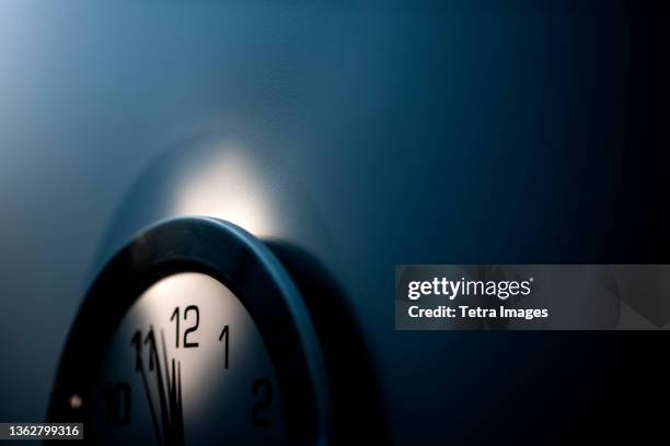close-up of wall clock with hands approaching midnight - meia noite - fotografias e filmes do acervo