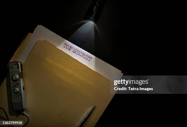 overhead view of top secret documents on desk top - confidential englischer begriff stock-fotos und bilder
