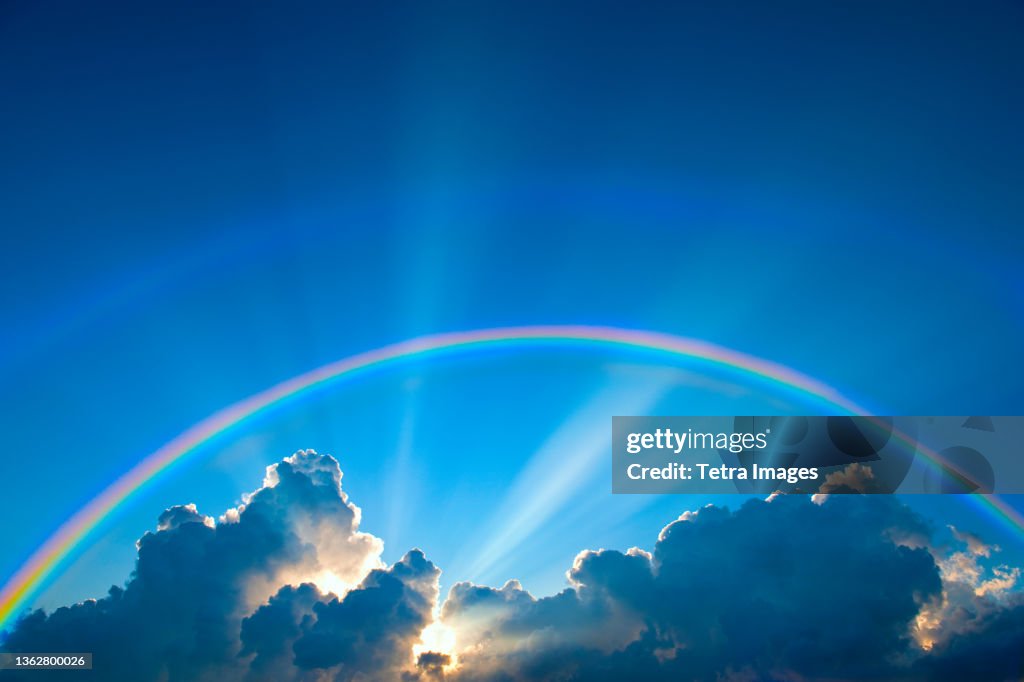 Double rainbow and clouds on sky at sunset