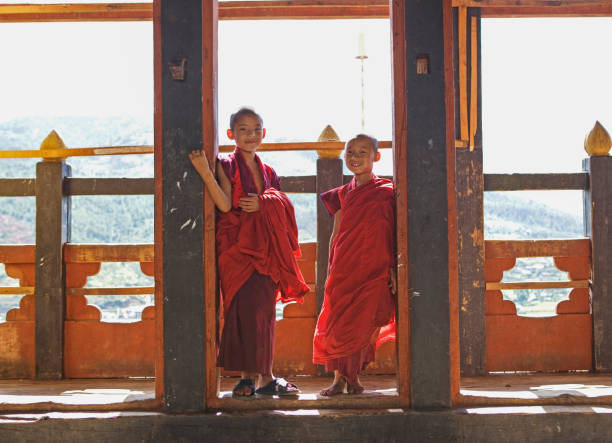 bhutan, paro, young buddhist monk novices (6-7, 10-11) in buddhist temple - bhutan monk stock pictures, royalty-free photos & images
