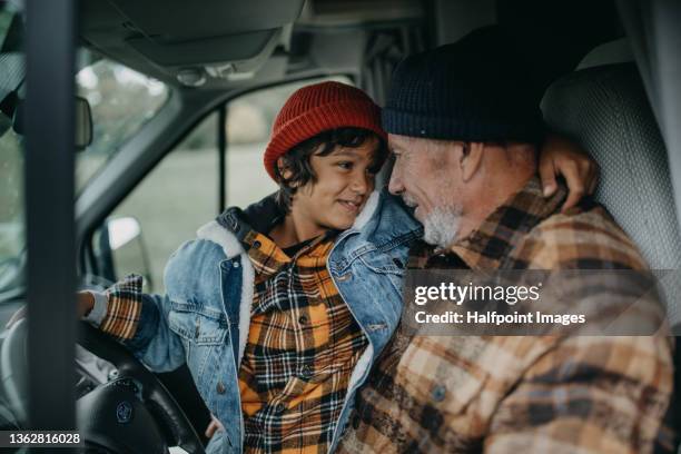 senior man with his grandson sitting in caravan in autumn day. - family caravan stockfoto's en -beelden