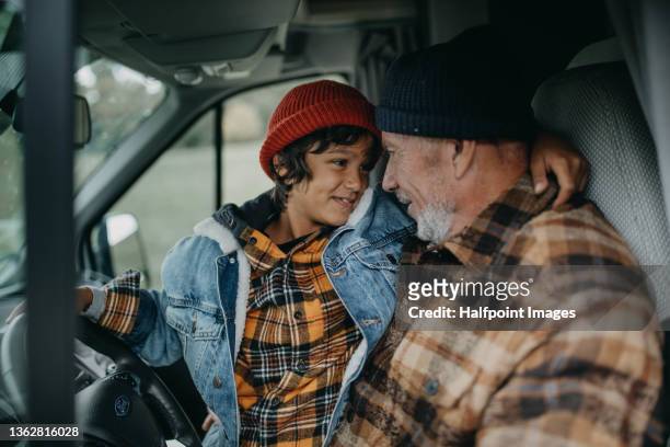 senior man with his grandson sitting in caravan in autumn day. - family inside car - fotografias e filmes do acervo