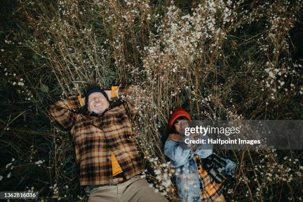 high angle view of boy with his grandfather lying down outdoors in grass in autumn day - child with binoculas stockfoto's en -beelden