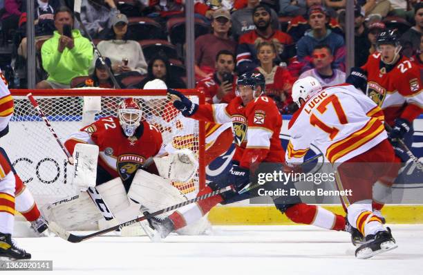 Sergei Bobrovsky and Patric Hornqvist of the Florida Panthers defend the net against Milan Lucic of the Calgary Flames during the first period on...