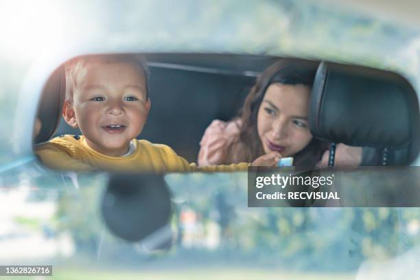 mother and son in the rear view mirror of the car. - boy playing with cars stock pictures, royalty-free photos & images