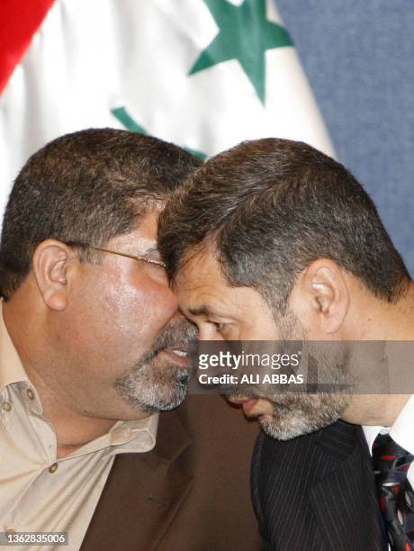 Head of al-Sadr parliamentary bloc Nassar Al-Rubaie speaks with an unidentified member of Al-Sadr bloc during a press conference in Baghdad, 16 April...